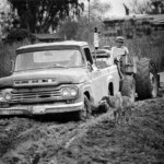 John Whelan pushing Ellen Whelan's truck through the mud